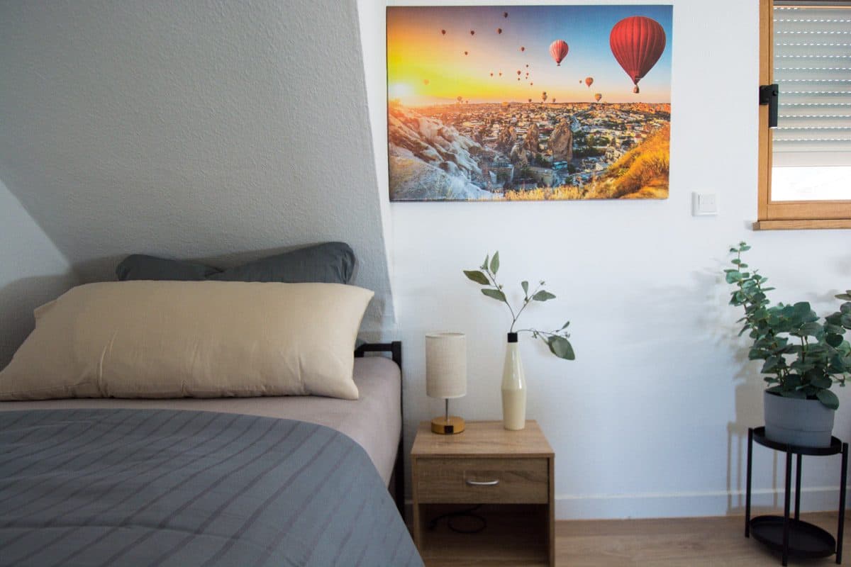 Frisch bezogenes Bett mit Nachttisch