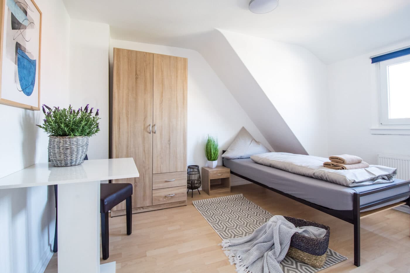 Einzelbett mit Arbeitsplatz in einer GLL-Wohnung