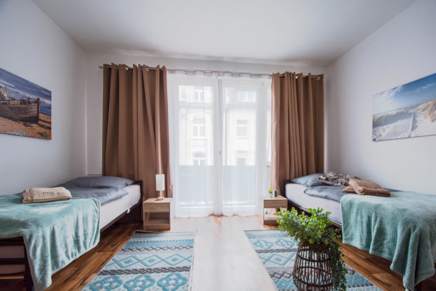 Zimmer mit zwei Betten vor bodentiefem Fenster
