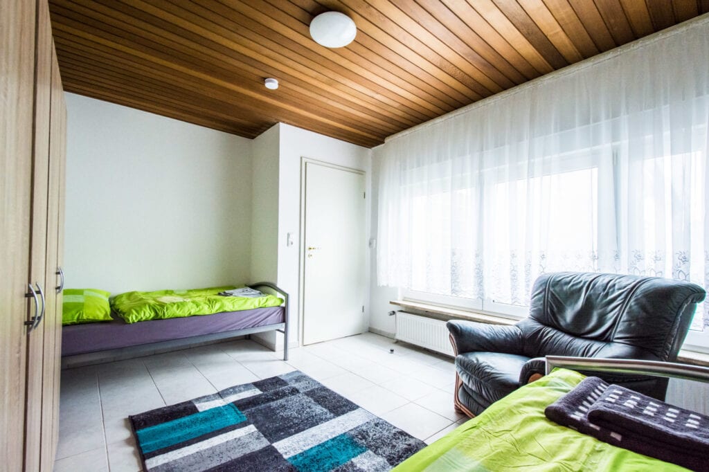 Zimmer mit Bett und Sessel, Monteurwohnung in Mainz